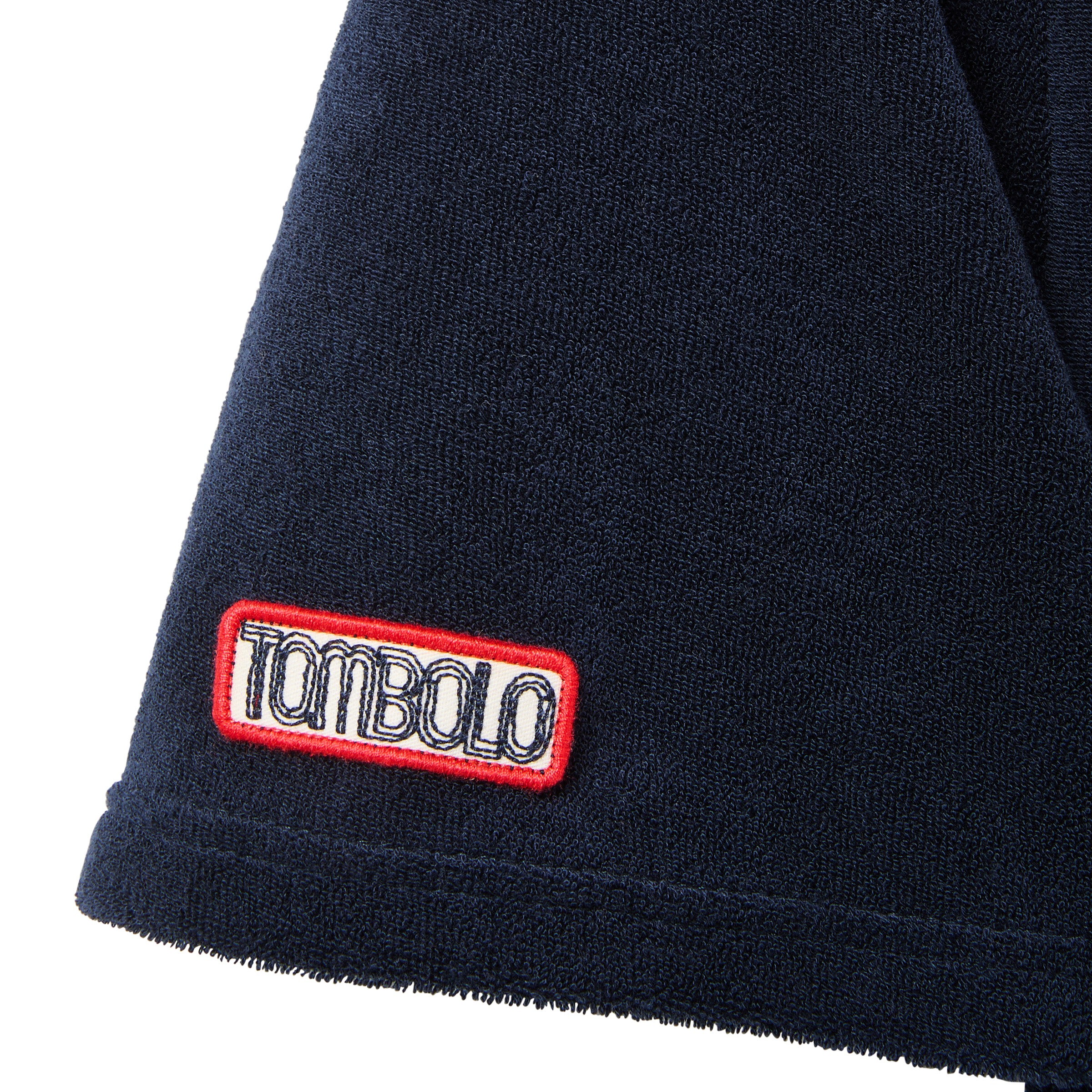 Navy blue terrycloth sleeve with a red and white 'Tombolo' logo patch.