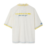 Back of a cream terry cloth polo shirt with a yellow contrast collar, blue contrast stitching, yellow embroidered “FIFA World Cup 26™” text on the upper back, blue “where were you?” embroidery, and a FIFA World Cup sleeve patch.