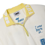 Close-up of a white polo shirt with yellow collar and text, featuring the FIFA 26 interior label.