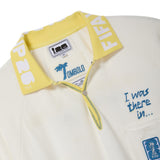 Close-up of a white polo shirt with yellow collar and text, featuring the FIFA 26 interior label.