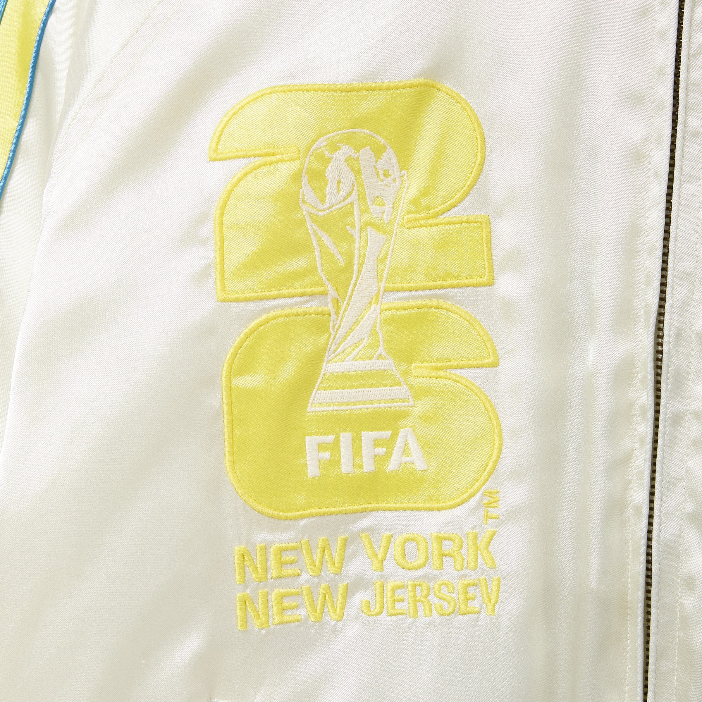 Embroidered FIFA logo on a white jacket with 'New York New Jersey' text.