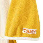 Yellow towel sleeve a white label featuring the brand 'Tombolo' on a white background