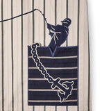 Close up of striped shirt with navy pocket Graphic of man fishing and anchor across the pocket