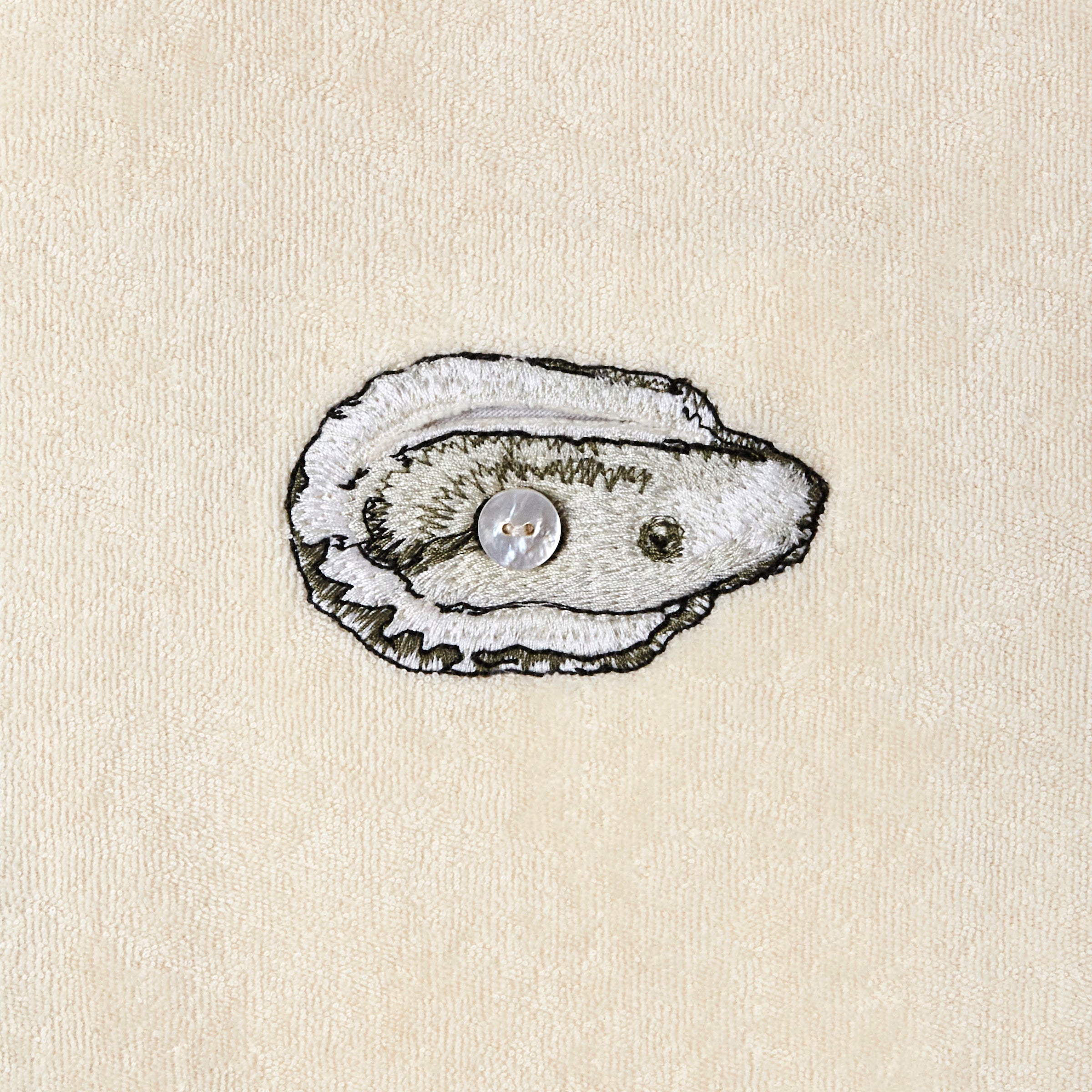Embroidered oyster close up with button in middle