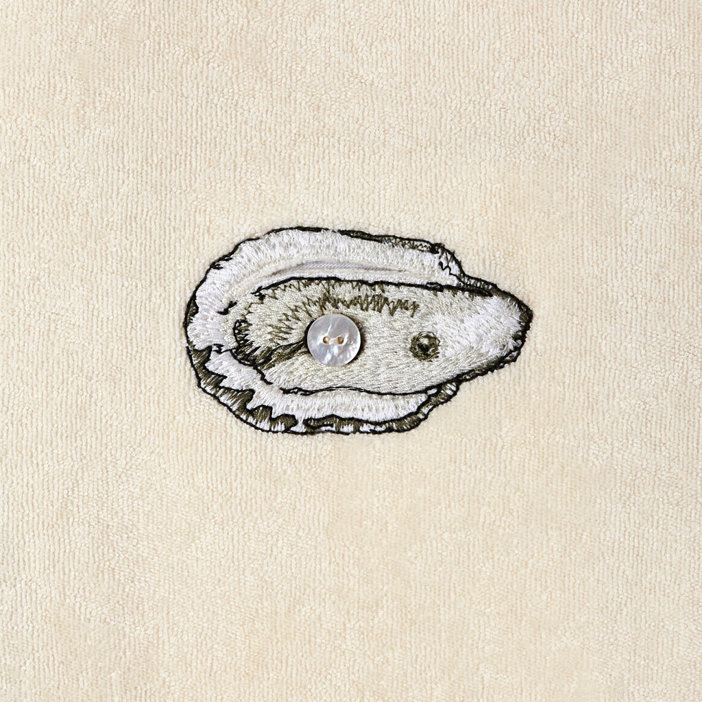 Embroidered oyster close up with button in middle