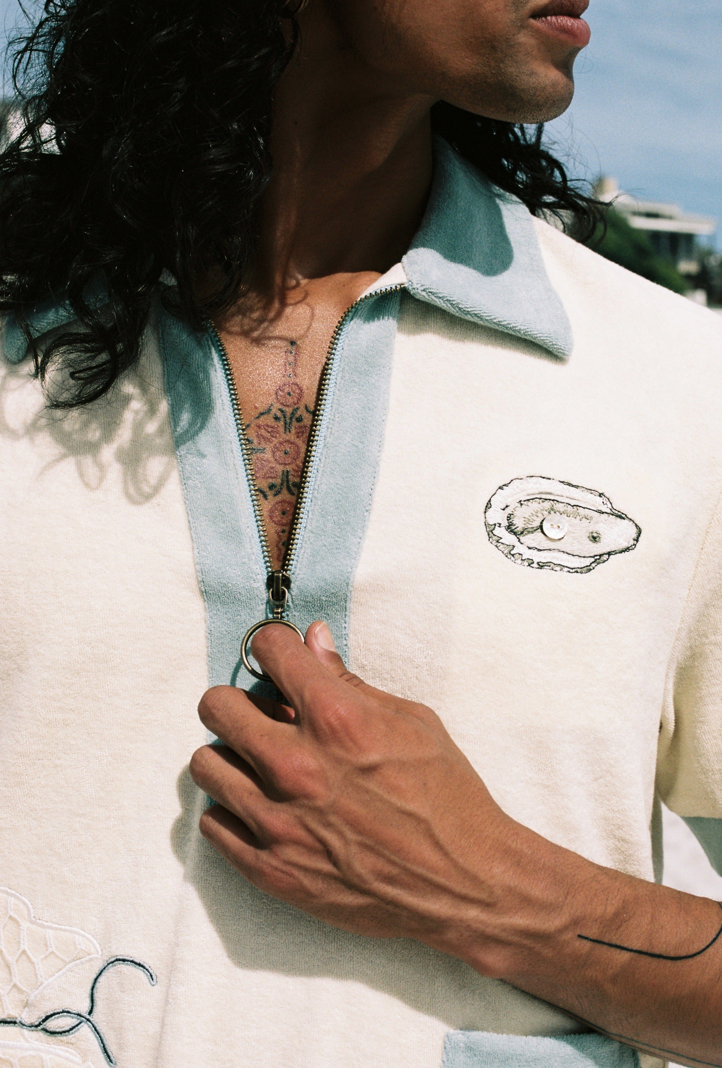 Close up of man holding zipper down wearing oyster terry cloth shirt