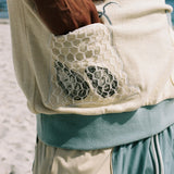 man puts hand inside mesh netted oyster pocket