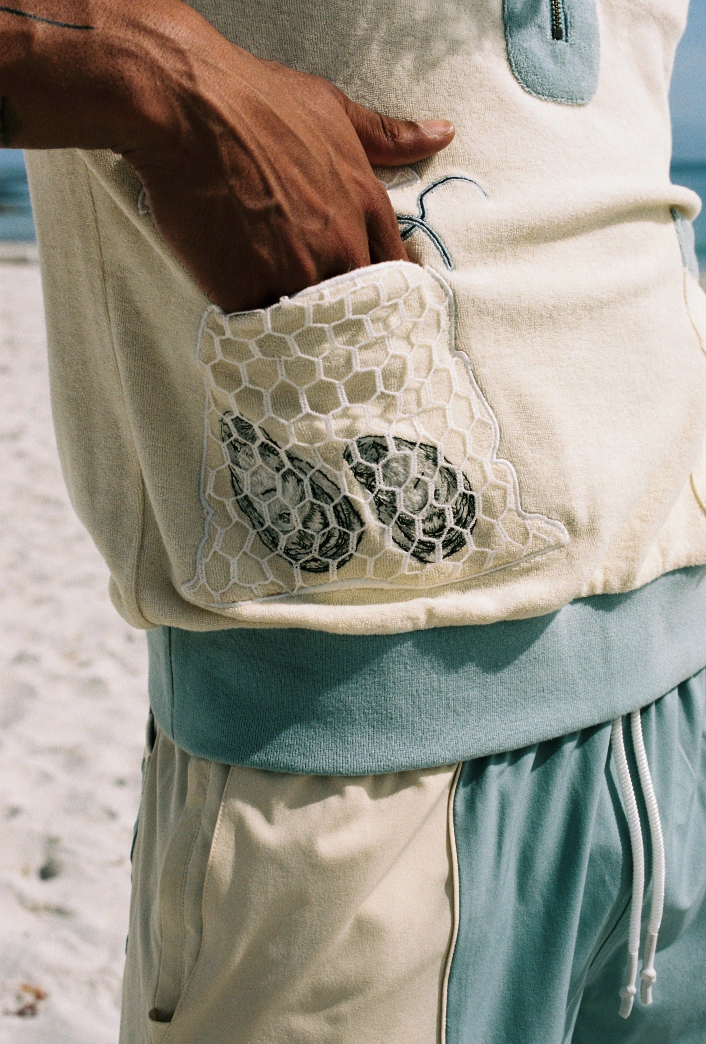 man puts hand inside mesh netted oyster pocket