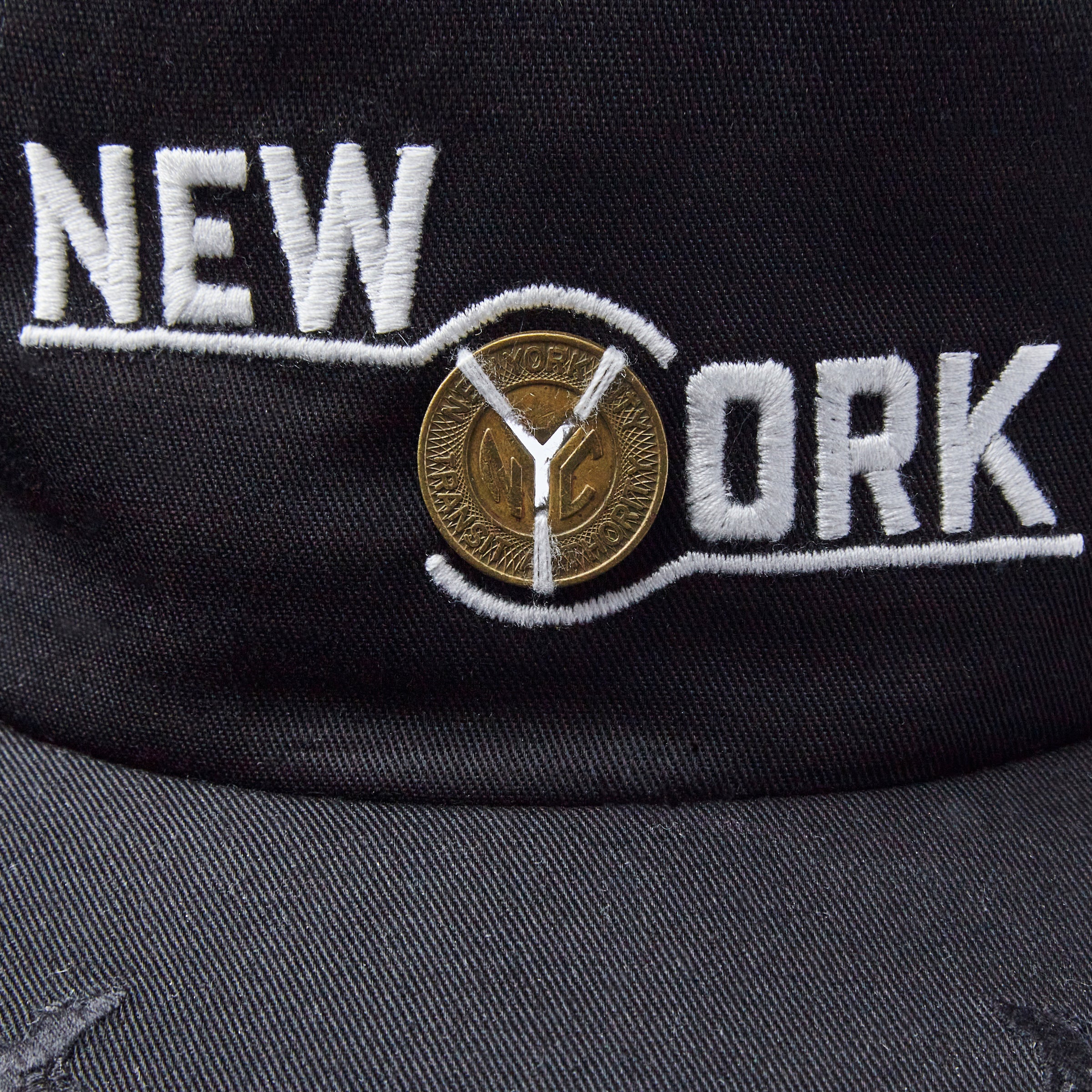 Close up of New York label embrodiery with light passing through the Y cutout of the token