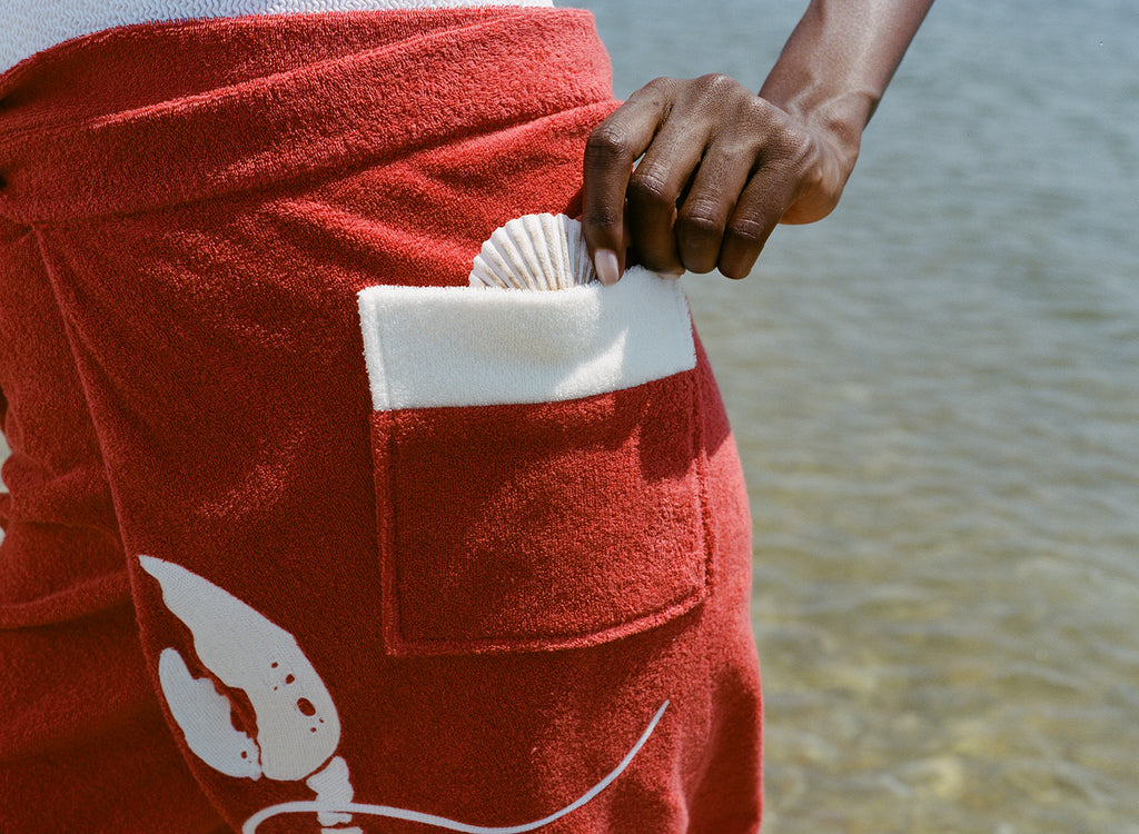 close up of red wrap skirt with shell peeking out of pocket