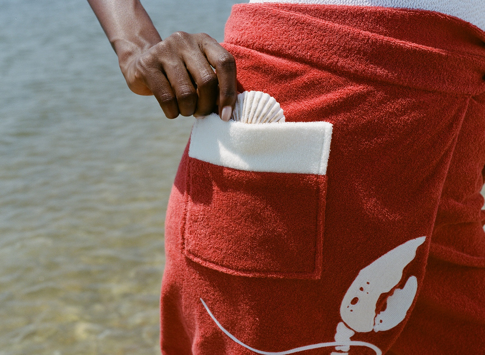 close up of red wrap skirt with shell peeking out of pocket