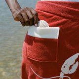 close up of red wrap skirt with shell peeking out of pocket