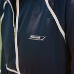 Close-up of the Boston Whaler logo on a navy sun shirt with white piping and a front zipper.