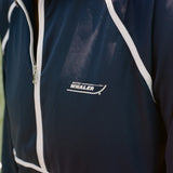 Close-up of the Boston Whaler logo on a navy sun shirt with white piping and a front zipper.