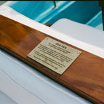 Brass plaque on wooden panel on 'Cea Pea' boat. 