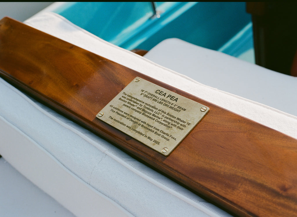 Brass plaque on wooden panel on 'Cea Pea' boat. 