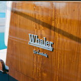 Close-up of 'Whaler by tombolo' logo featured on the boat. 