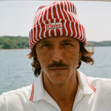 Man wearing red and white striped knit beanie with a 'Whaler' patch.