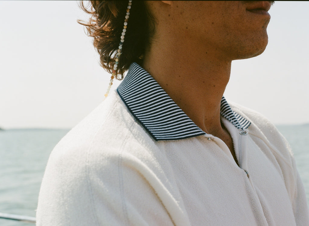 Close-up of the black-and-white striped collar on the white terry 'Whaler' polo. 