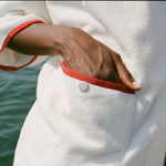 Close-up of woman's hand in front pocket of the hooded beach towel top. 