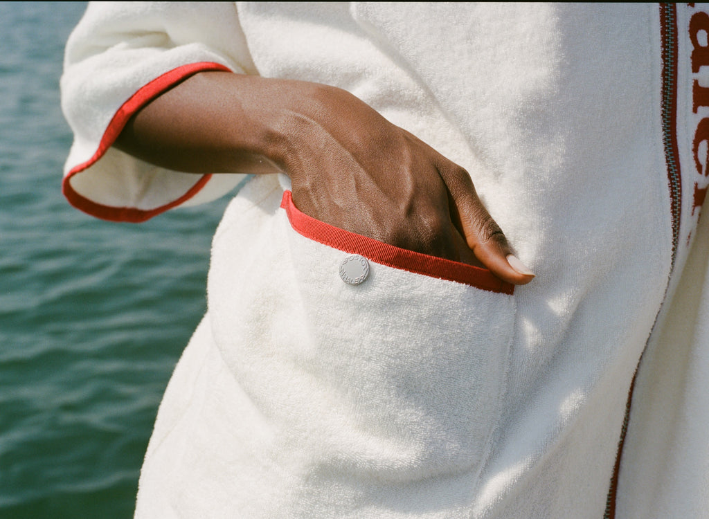 Close-up of woman's hand in front pocket of the hooded beach towel top. 