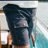 Close-up of the flap cargo pocket on the navy board shorts.