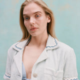 Female model with long blonde hair wearing the 'Rick Rack' Cabana ~ Crop Cut (Sky Blue) with a teal bikini top, shot on a light blue background.
