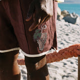 Close up of 'Tombarolo' cabana shorts with appliquéd grape bunch detail