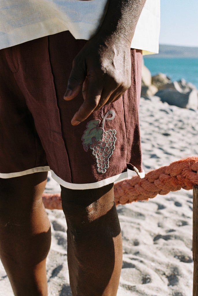 Close up of 'Tombarolo' cabana shorts with appliquéd grape bunch detail