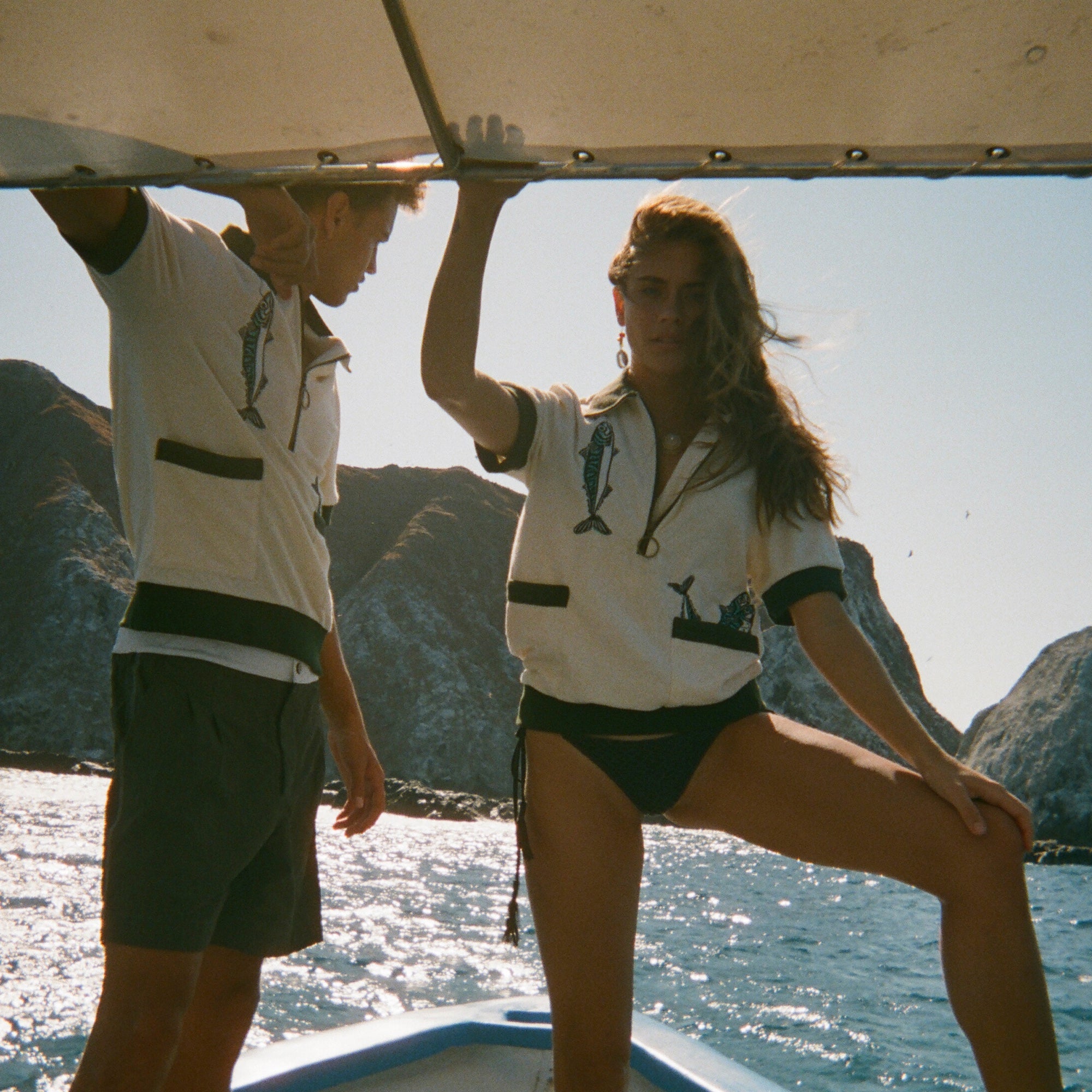 Two people on a boat wearing the Tombolo 'Angler' cabanas. 