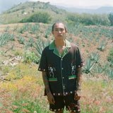 Man standing in field wearing full 'Picante' cabana set in linen.