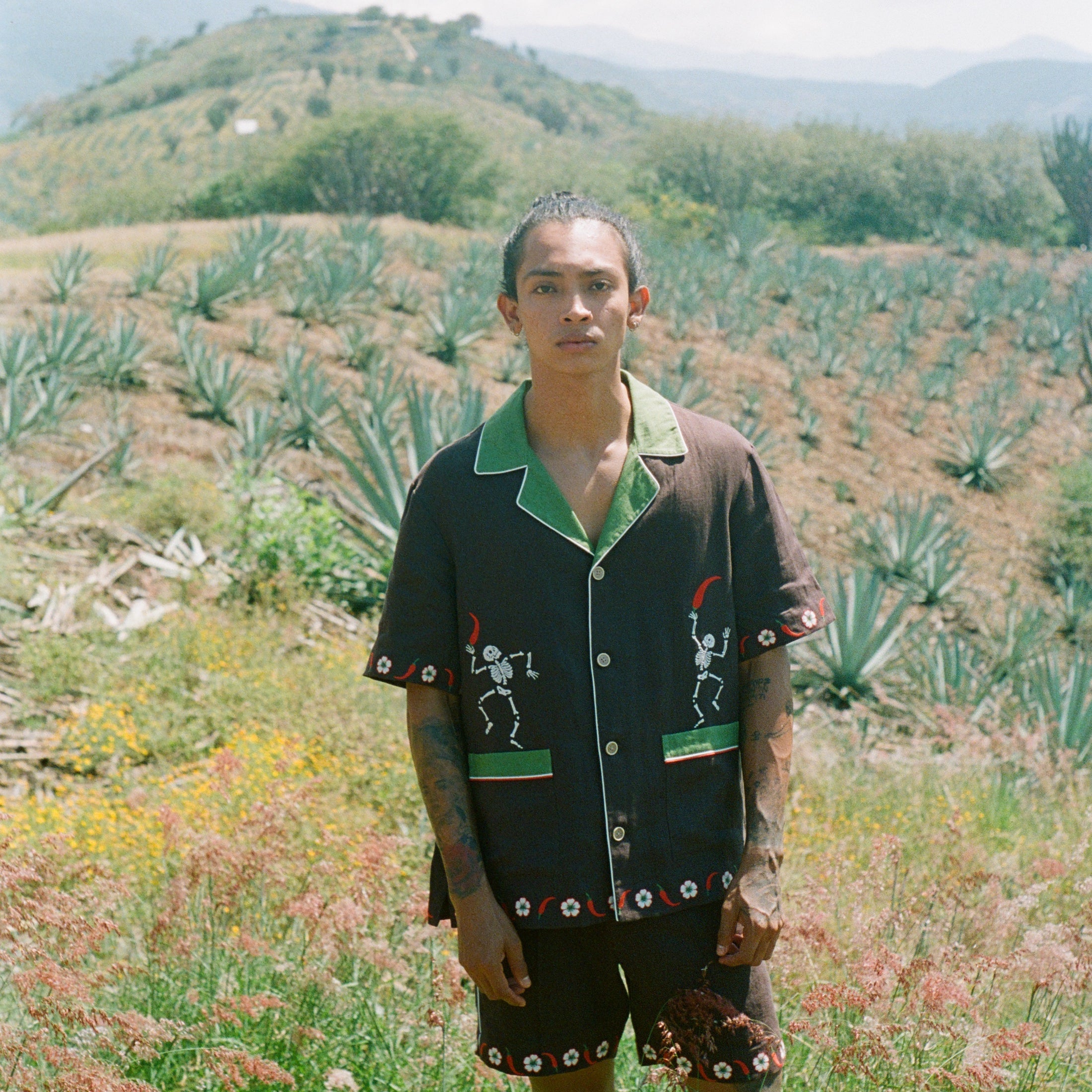 Man standing in field wearing full 'Picante' cabana set in linen.
