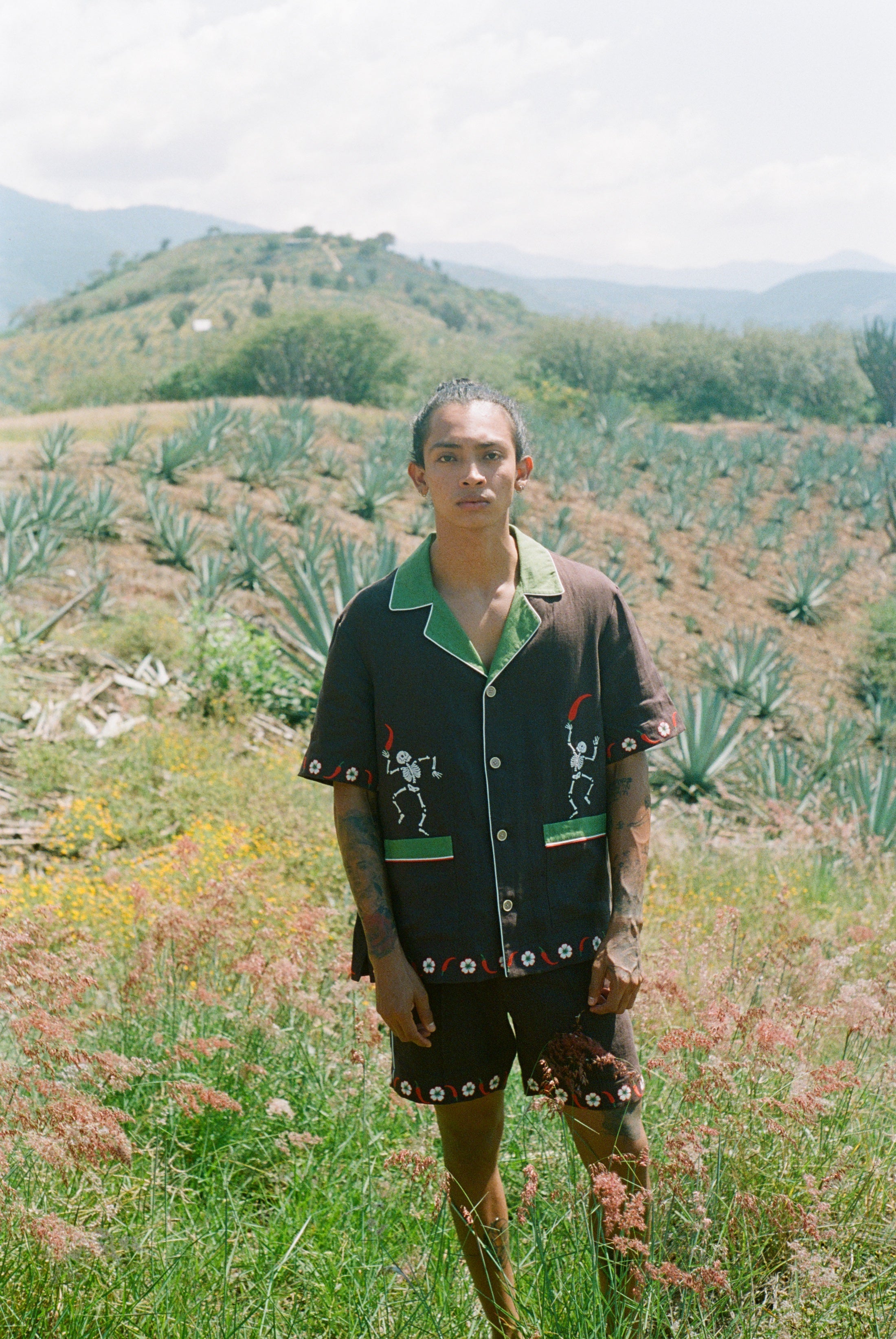 Man standing in field wearing full 'Picante' cabana set in linen.