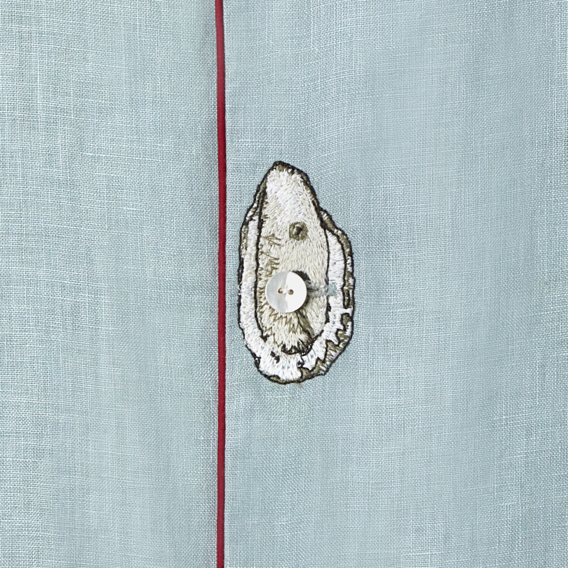 close up of embroidered oyster on top of middle shirt button