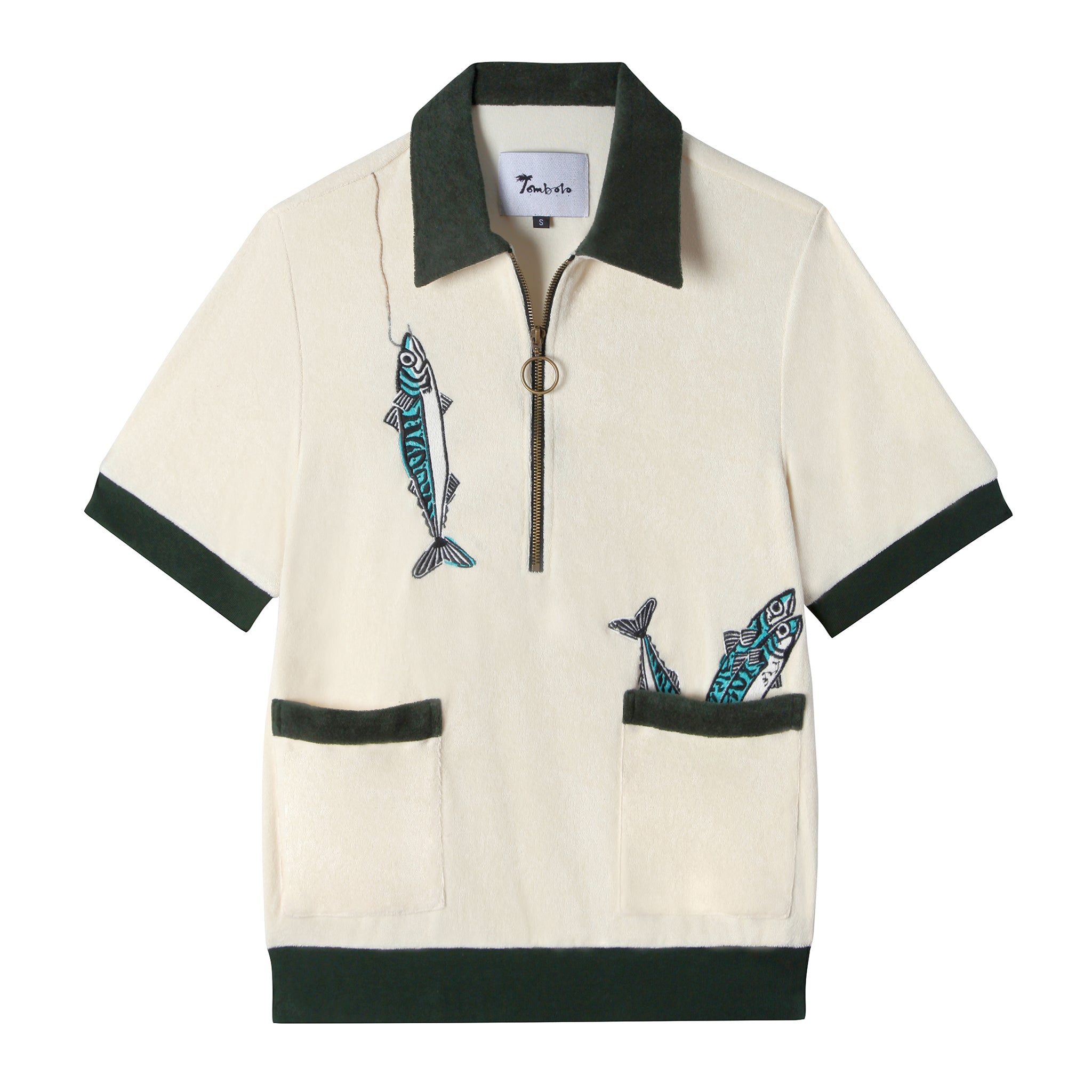 Front view of our Angler Cabana Shirt in cream with forest green on the collar, pockets, and bottom waistband, embroidered with a fish and a hook on the top left and two fish coming out of the bottom right pocket as well as featuring an antique brass half zip
