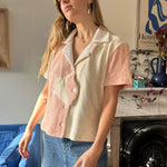 Aemelia looking off camera angle to the left corner wearing coral pink conched out shirt