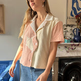 Aemelia looking off camera angle to the left corner wearing coral pink conched out shirt