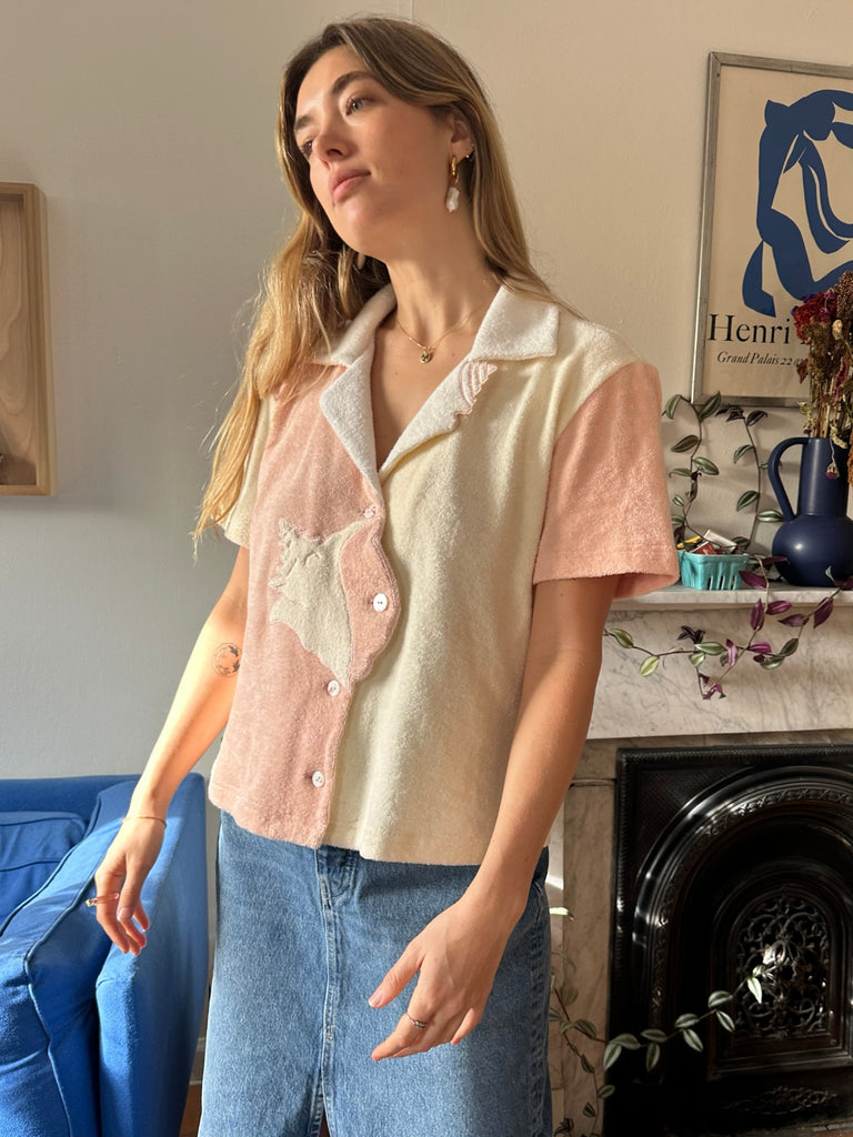 Aemelia looking off camera angle to the left corner wearing coral pink conched out shirt