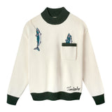 Cream knit sweater with dark green ribbed collar, cuffs, and hem. Features embroidered fish, including one hanging from a fishing line near the shoulder and two peeking out from a chest pocket. 'Tombolo' embroidered near the waist.