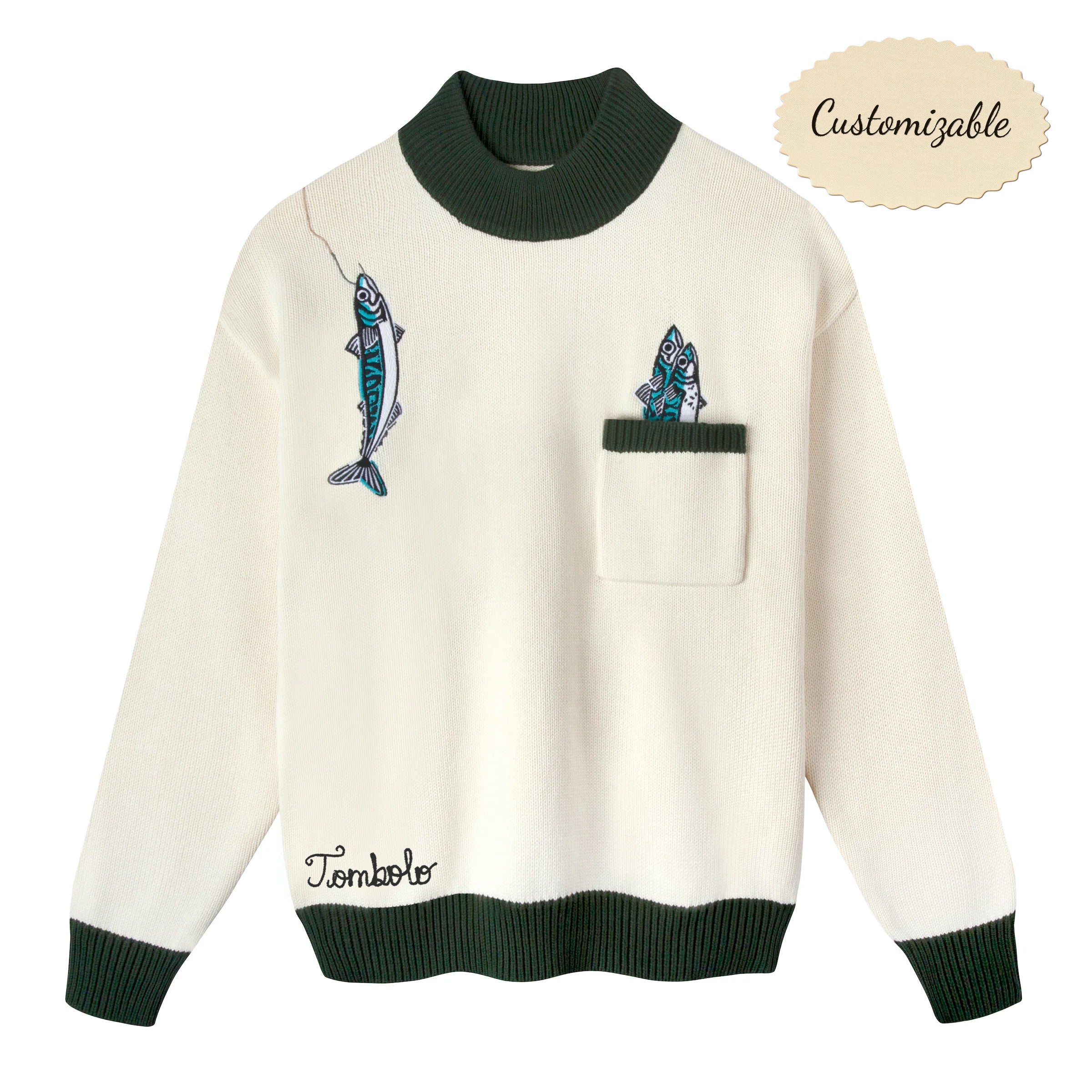 Cream knit sweater with dark green ribbed collar, cuffs, and hem. Features embroidered fish, including one hanging from a fishing line near the shoulder and two peeking out from a chest pocket. 'Tombolo' embroidered near the waist.