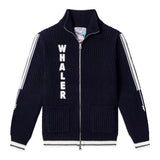 Navy knit zip-up cardigan with vertical 'WHALER' text in white on the left side. Features two front patch pockets, white stripes down the sleeves, and contrast ribbing at the cuffs and hem.