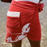 Close up of woman at beach wearing white bathing suit and red tie wrap skirt