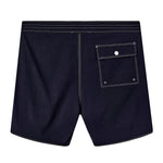 Backside of navy board shorts with white contrast stitching, and one flap pocket on the right side.