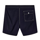 Backside of navy board shorts with white contrast stitching, and one flap pocket on the right side.