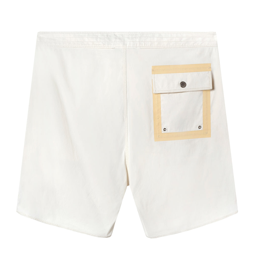 Back view of white board shorts with a single beige-trimmed flap pocket on the right side, secured with metal snaps.