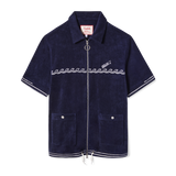 Front-facing product image of the 'Boston Whaler' Cabana (Navy) that features a chainstitched harpoon hull stripe on cuffs and bottom sweep, embroidered 'Boston Whaler' surfing a following sea of chainstitched repeating waves, drawstrings with barrel stopper knots, two-way, nickel zipper with ring pull, custom 'Tombolo & Boston Whaler' woven interior label secured with zig-zag sail stitch, and front patch pockets with nickel snaps embossed with 'Boston Whaler.'
