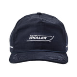 Front view of a navy blue baseball cap with white embroidered text and logo reading “Boston Whaler,” styled to resemble the outline of a boat. The brim features subtle distressed detailing, and there is a thin blue rope accent above the brim. White embroidered stripes appear on the sides of the cap.