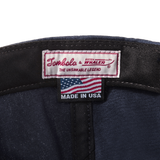 Close-up product image of the 'Boston-Whaler' 5-Panel Souvenir Cap's interior tag with Tombolo & Boston Whaler logos and 'the unsinkable legend' text below that with a made in the USA tag as well.