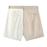 Back view of two-tone pleated shorts in beige and off-white. Features include belt loops, two welt pockets with button closures, and a small rectangular 'Tombolo' logo patch above the left pocket.