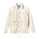Front view of a cream hooded rain jacket with tan trim, silver snap buttons, and two large front pockets. Features the Boston Whaler logo on the left chest.
